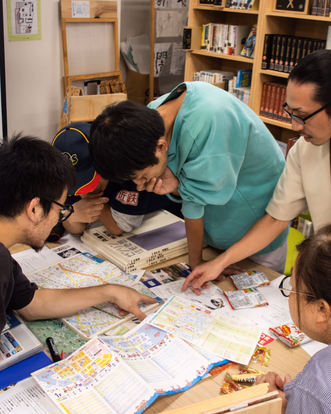 机に広げた地図を数人で囲み、指さしながら話しているまちラボの様子