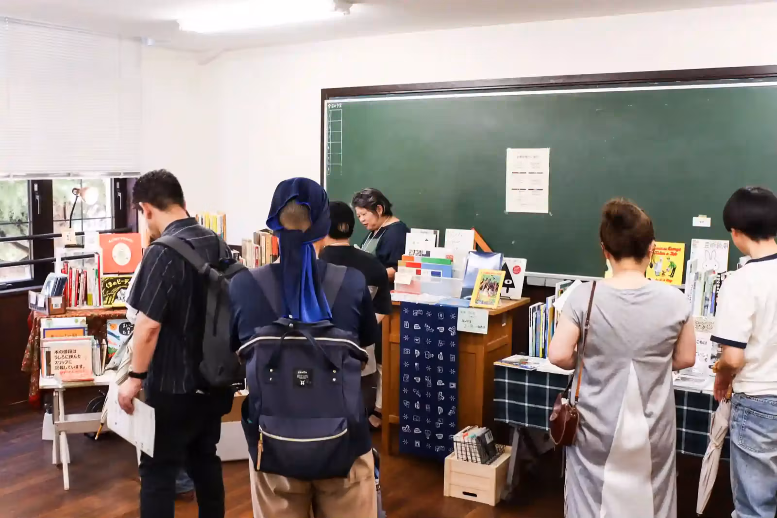 過去開催の会場風景。黒板のある教室に並んだZINEのブースを来場者が見て回っている